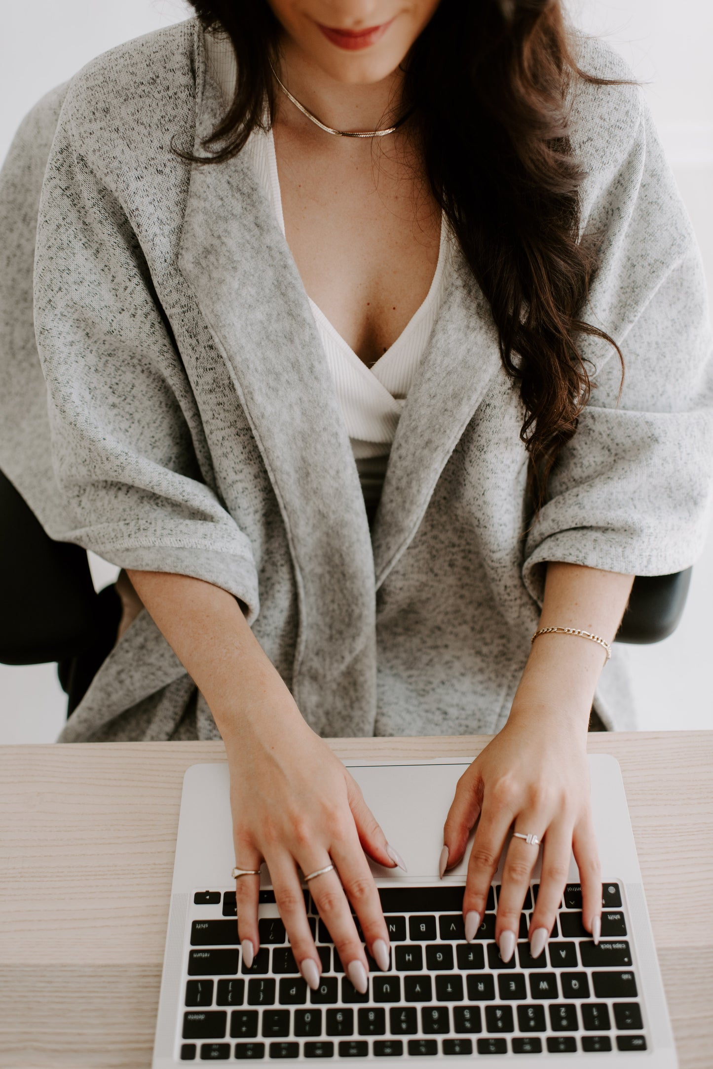 Hands typing on a keyboard while wearing the Warmür office chair blanket; lapels folded back for a polished look